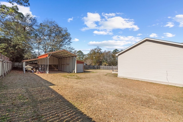 view of yard featuring a carport, an outdoor structure, and a garage