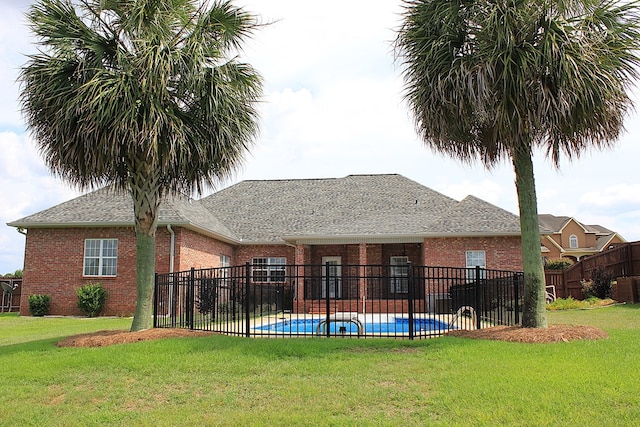 105 Frisco Ln, Enterprise, AL 36330 - rear view of house featuring a fenced in pool, a lawn, roof with shingles, and brick siding