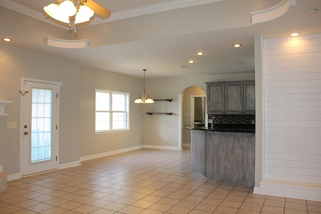 105 Frisco Ln, Enterprise, AL 36330 - kitchen featuring dark countertops, tasteful backsplash, arched walkways, ceiling fan with notable chandelier, and light tile patterned floors