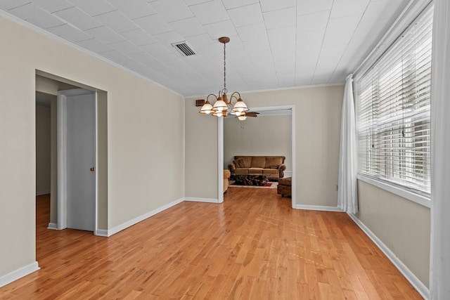 unfurnished dining area with a chandelier, crown molding, and light hardwood / wood-style flooring