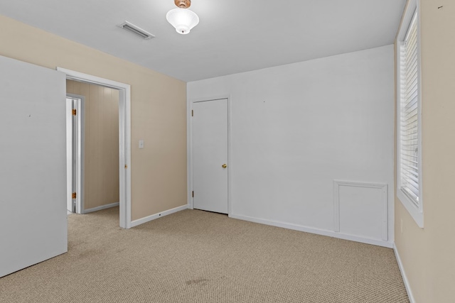 unfurnished bedroom featuring multiple windows and light carpet