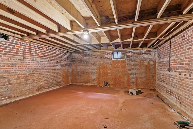 basement featuring brick wall