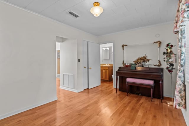 miscellaneous room with light hardwood / wood-style floors and ornamental molding