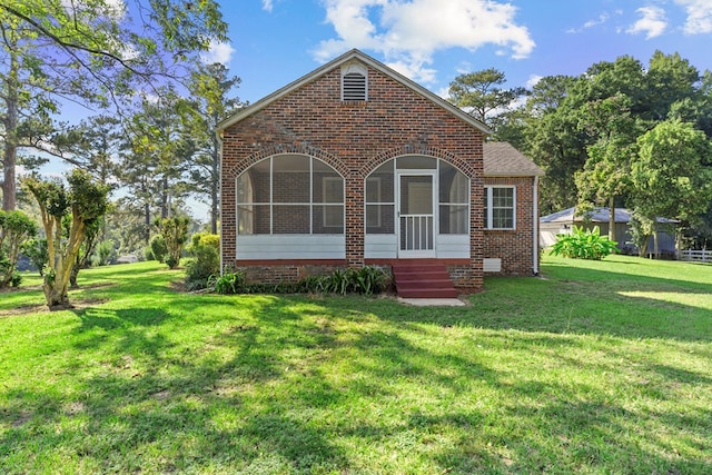 view of front of property with a sunroom and a front lawn