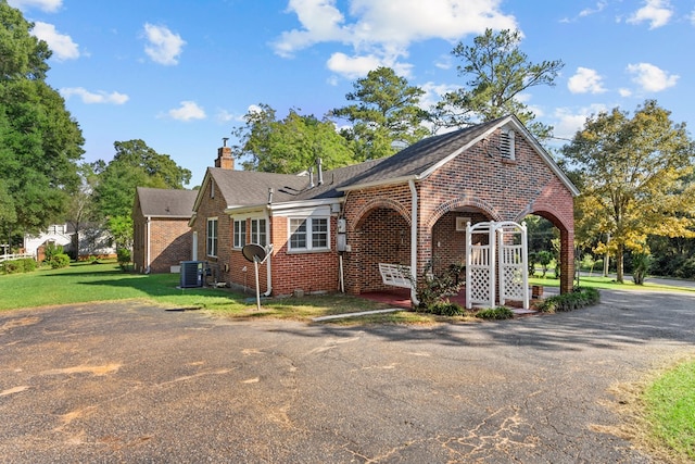 view of front of property with a front lawn and central air condition unit