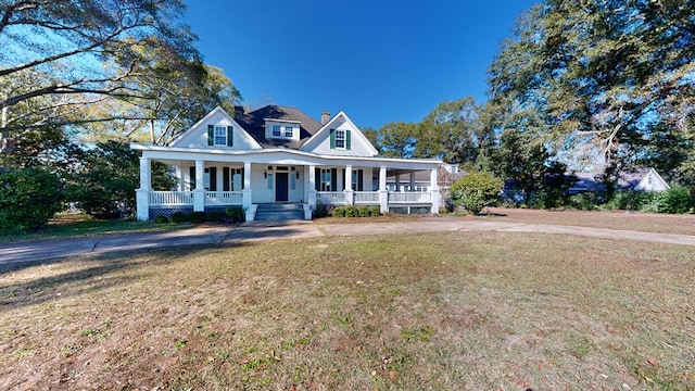 farmhouse-style home with covered porch and a front yard