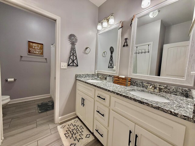 1243 Silcox Rd, Ashford, AL 36312 - full bathroom with double vanity, toilet, and baseboards