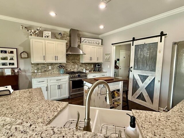 1243 Silcox Rd, Ashford, AL 36312 - kitchen featuring wall chimney exhaust hood, stainless steel appliances, crown molding, a sink, and white cabinetry