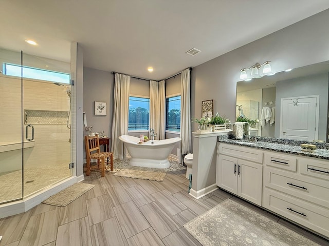 1243 Silcox Rd, Ashford, AL 36312 - full bathroom featuring vanity, a shower stall, a freestanding tub, toilet, and recessed lighting
