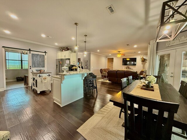 1243 Silcox Rd, Ashford, AL 36312 - dining room with ornamental molding, a barn door, a ceiling fan, baseboards, and dark wood finished floors