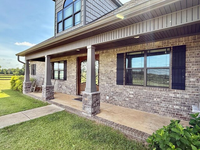 1243 Silcox Rd, Ashford, AL 36312 - doorway to property with covered porch, brick siding, and a yard