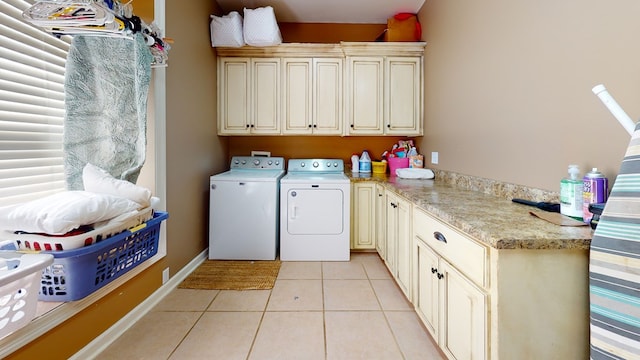 clothes washing area featuring cabinets, separate washer and dryer, and light tile patterned floors