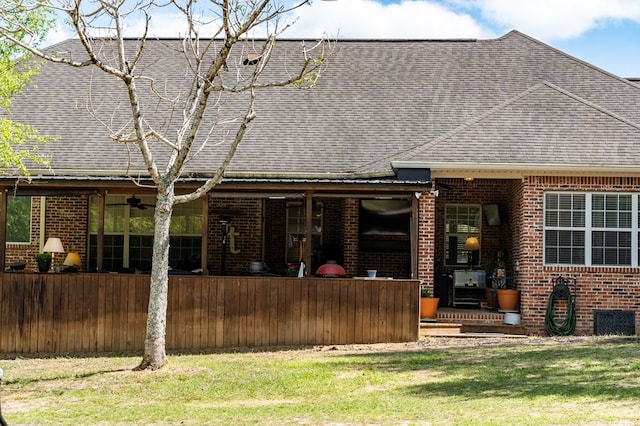 back of property featuring a yard and ceiling fan