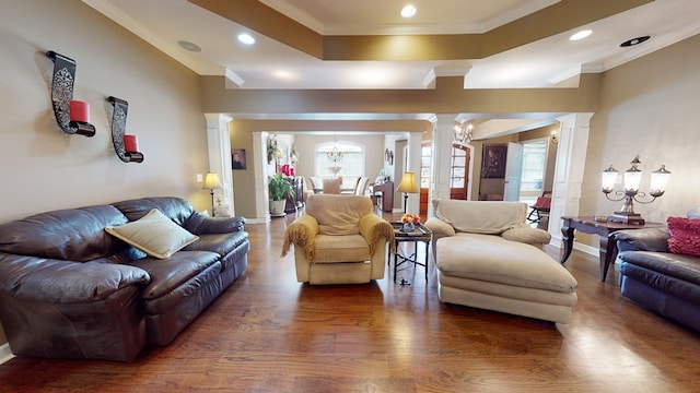 living room with a chandelier, dark hardwood / wood-style flooring, ornate columns, and ornamental molding