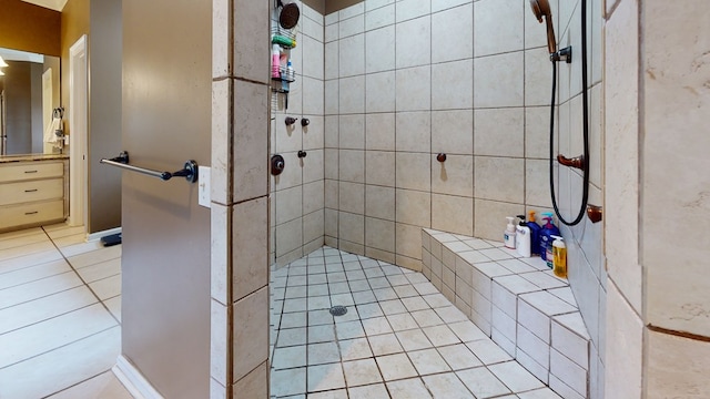 bathroom with a tile shower and tile patterned flooring