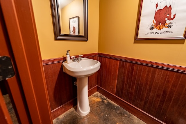 bathroom featuring wooden walls