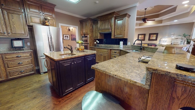 kitchen with appliances with stainless steel finishes, dark hardwood / wood-style flooring, a center island with sink, and sink