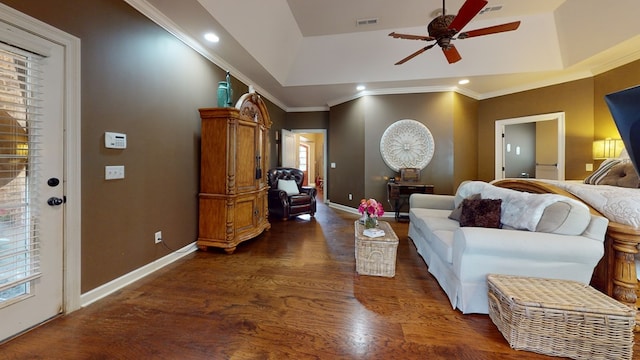 living room with a tray ceiling, crown molding, ceiling fan, and dark wood-type flooring