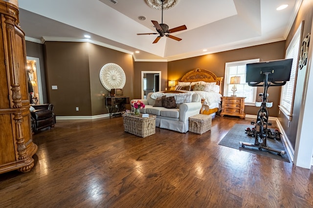 bedroom with dark hardwood / wood-style floors, ceiling fan, ornamental molding, and a tray ceiling