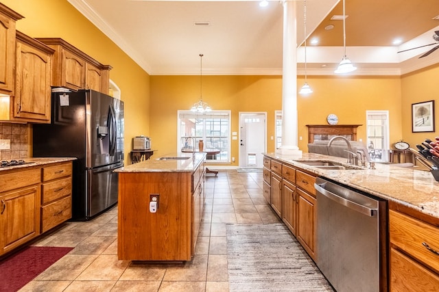 kitchen featuring a kitchen island with sink, stainless steel appliances, crown molding, pendant lighting, and decorative backsplash