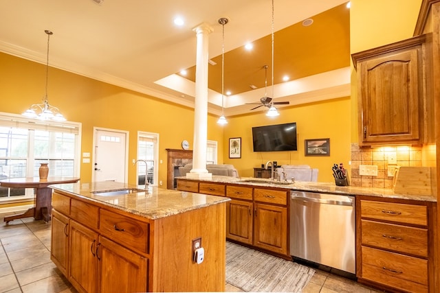 kitchen featuring a kitchen island with sink, sink, stainless steel dishwasher, and decorative light fixtures