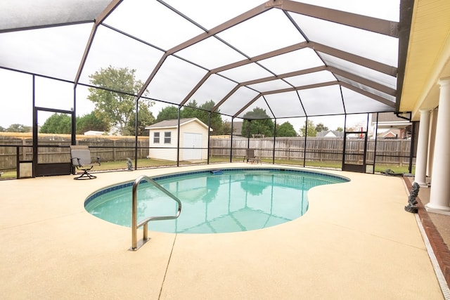 view of pool with glass enclosure, a patio area, and a shed