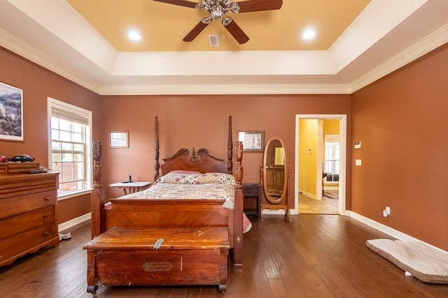 bedroom with a raised ceiling, ceiling fan, dark hardwood / wood-style flooring, and crown molding