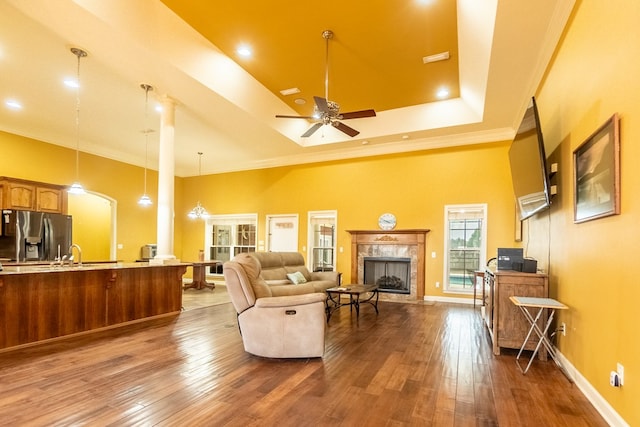 living room with crown molding, hardwood / wood-style floors, and a towering ceiling