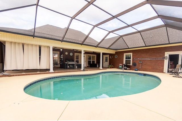 view of pool with ceiling fan, a lanai, and a patio