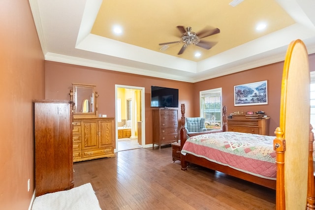 bedroom with a raised ceiling, crown molding, ensuite bath, ceiling fan, and dark hardwood / wood-style flooring