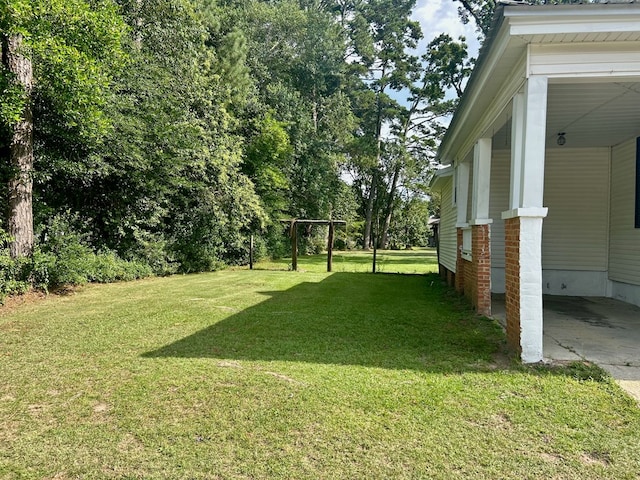 403 W Main St, Samson, AL 36477 - view of green lawn featuring a carport and driveway