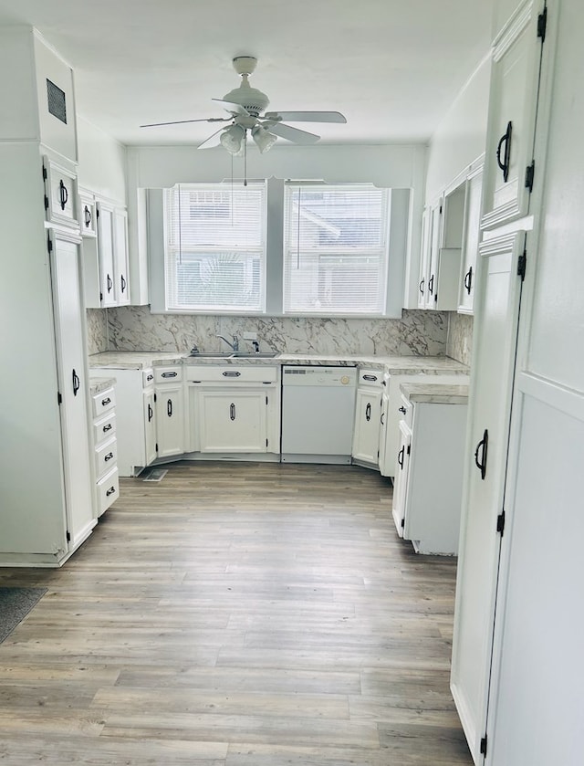 403 W Main St, Samson, AL 36477 - kitchen with dishwasher, ceiling fan, white cabinets, light wood-style flooring, and decorative backsplash
