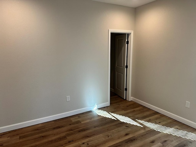 unfurnished room with baseboards and wood finished floors