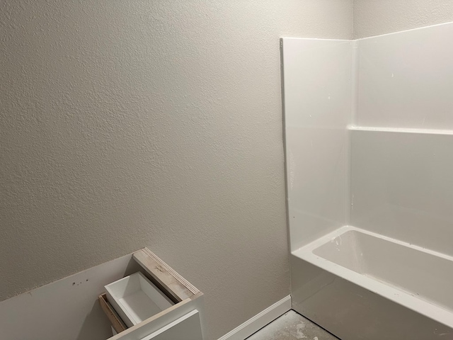 bathroom with baseboards and a textured wall