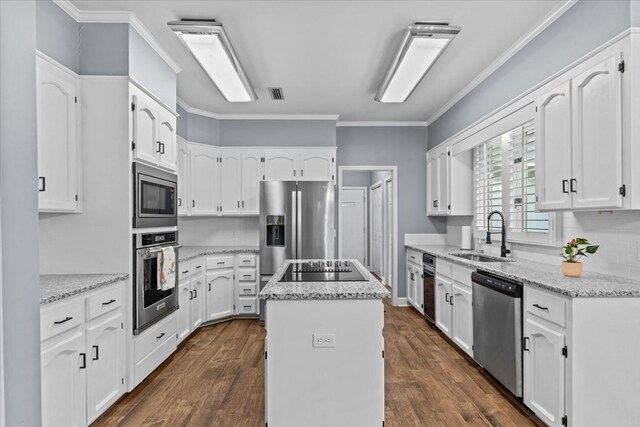 kitchen with a sink, a center island, visible vents, white cabinets, and appliances with stainless steel finishes