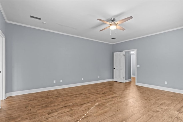 unfurnished room featuring crown molding, visible vents, baseboards, wood finished floors, and a ceiling fan