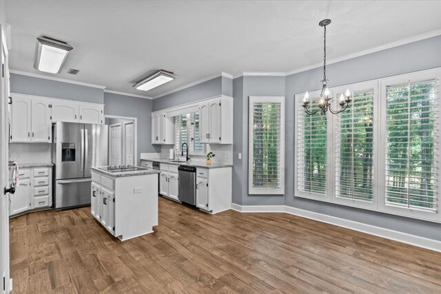 kitchen featuring white cabinetry, stainless steel appliances, a chandelier, and a sink