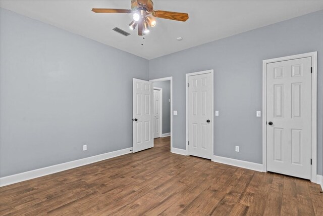 unfurnished bedroom with baseboards, visible vents, wood finished floors, and ceiling fan
