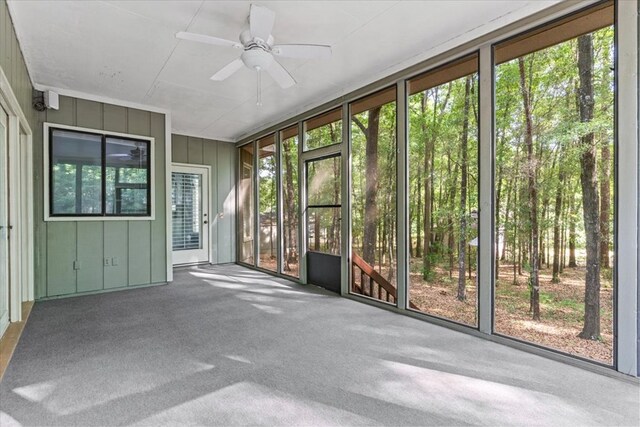 unfurnished sunroom featuring ceiling fan