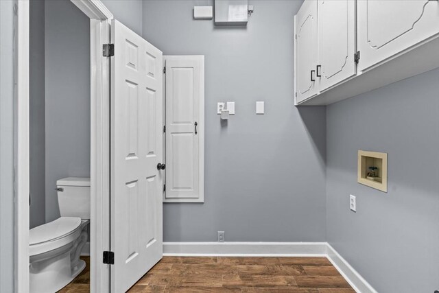 washroom with hookup for a washing machine, cabinet space, dark wood-style floors, and baseboards