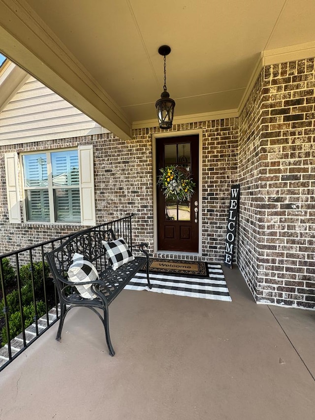 property entrance featuring brick siding and a porch