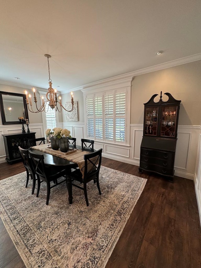 dining room with ornamental molding, dark wood-style flooring, a decorative wall, wainscoting, and a notable chandelier