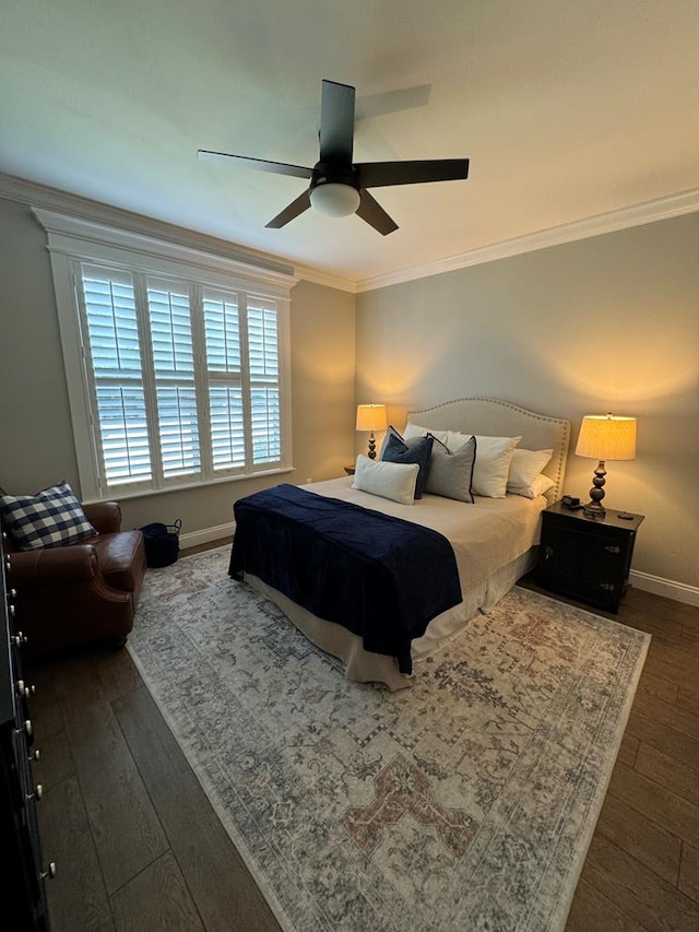 bedroom with a ceiling fan, baseboards, dark wood-type flooring, and ornamental molding