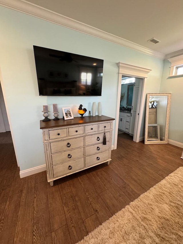 room details with visible vents, baseboards, wood finished floors, and ornamental molding