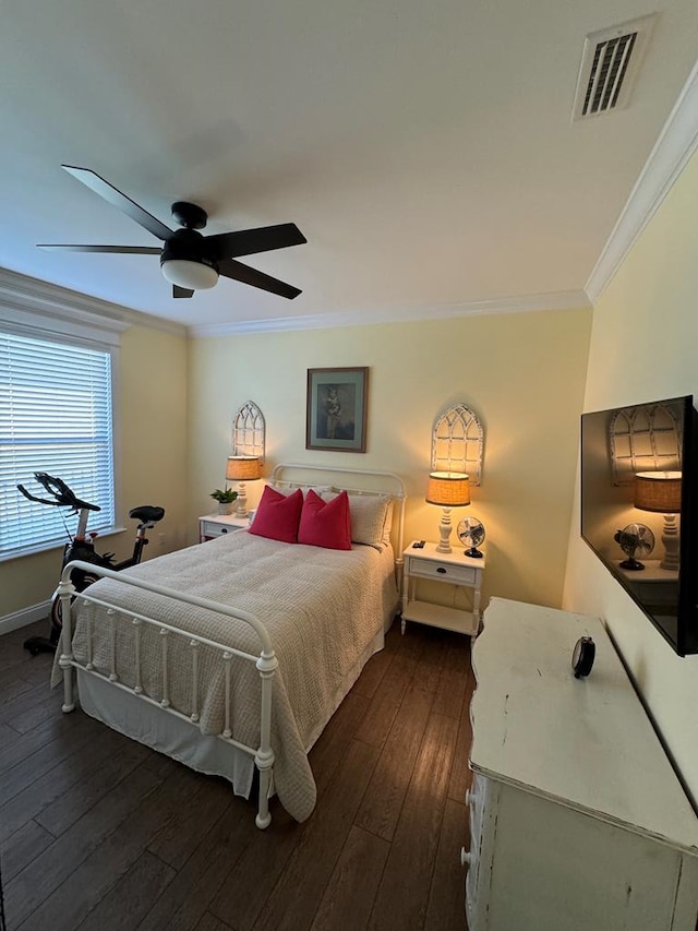 bedroom with ceiling fan, dark wood-style floors, crown molding, and visible vents