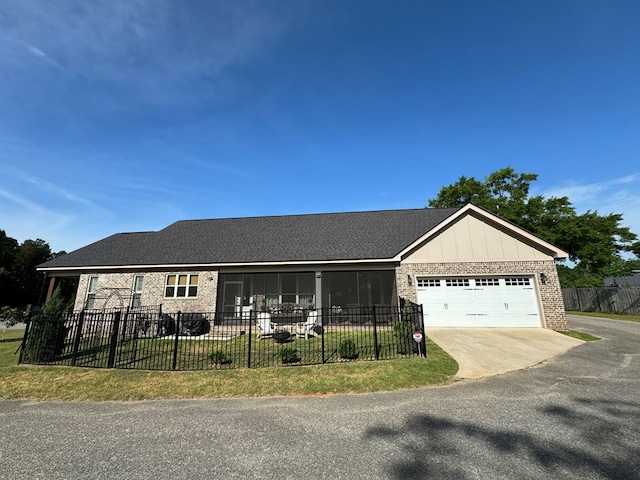 single story home featuring driveway, brick siding, a garage, fence private yard, and a front yard