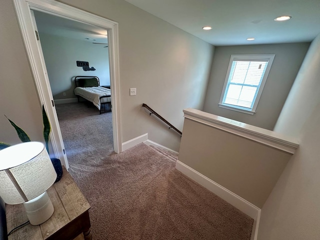 corridor featuring recessed lighting, baseboards, an upstairs landing, and carpet