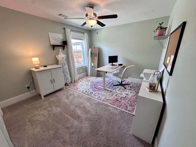 office area featuring baseboards, visible vents, a ceiling fan, and light colored carpet