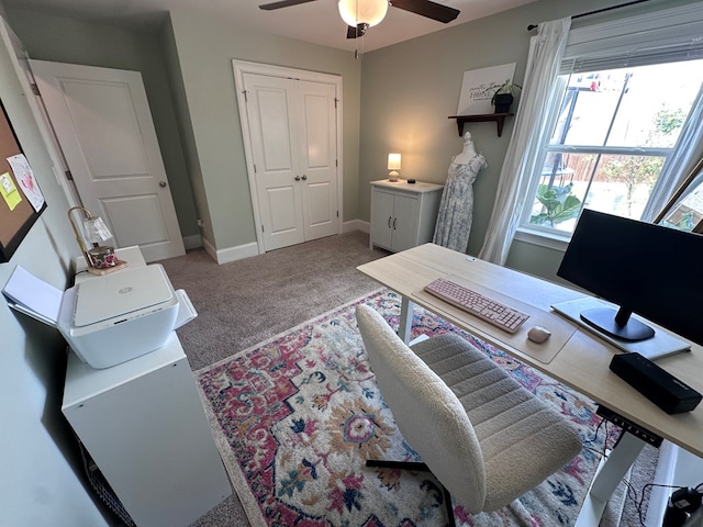 carpeted home office with baseboards and ceiling fan