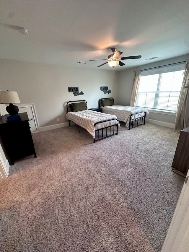 bedroom with a ceiling fan, baseboards, visible vents, and carpet